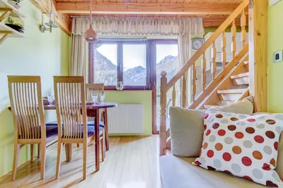 a dining room with a table and chairs and a window at Outstanding Lake View. in Kranjska Gora