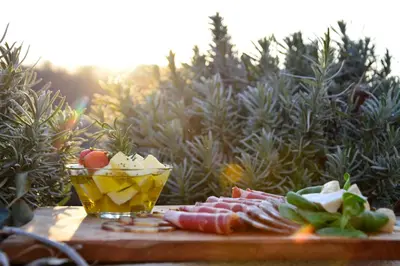a plate of food and a drink on a cutting board at Hotel Dolenjc in Novo Mesto