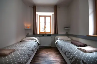 three beds in a room with a window at CUBE central rooms for 2 in Ljubljana