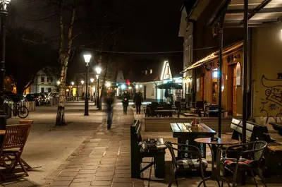 a person walking down a street at night at CUBE central rooms for 2 in Ljubljana