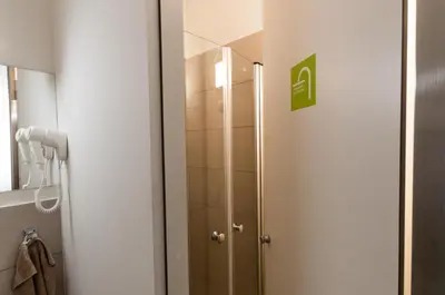 a shower in a bathroom with a glass door at CUBE central rooms for 2 in Ljubljana