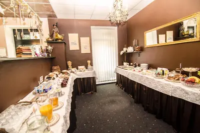 a dining room with long tables with food on them at Trubarjev Art Boutique hotel in Laško