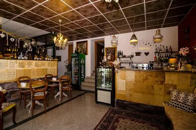 a restaurant with a table and chairs and a bar at Trubarjev Art Boutique hotel in Laško
