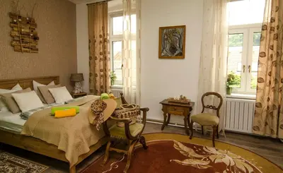 a bedroom with a bed and a table and chairs at Trubarjev Art Boutique hotel in Laško
