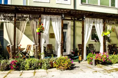 a patio with white curtains and some flowers at Trubarjev Art Boutique hotel in Laško