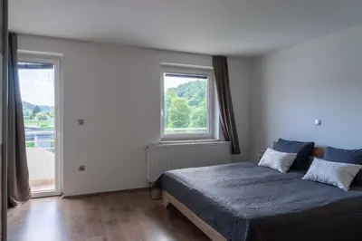 a bedroom with a bed and a large window at Apartments Ema in Podčetrtek