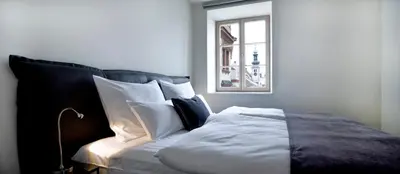 a bedroom with a bed with pillows and a window at Hotel Maribor, City apartments in Maribor