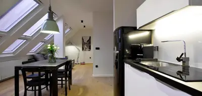 a kitchen with a table with chairs and a sink at Hotel Maribor, City apartments in Maribor