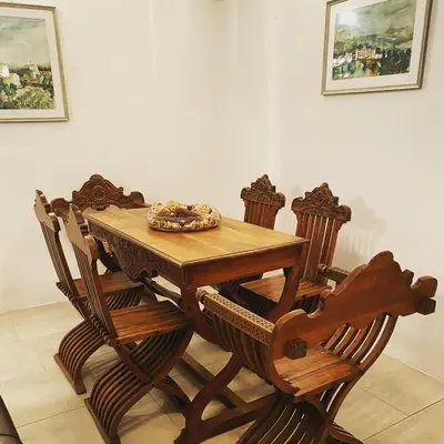 a wooden table with four chairs around it at Villa HerMes ArT in Dutovlje