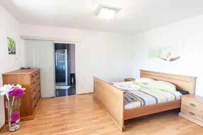 a bedroom with a bed and a wooden floor at Villa HerMes ArT in Dutovlje