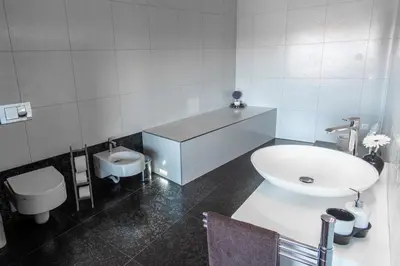 a white bathroom with a sink and a toilet at Villa HerMes ArT in Dutovlje