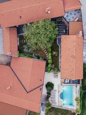 an overhead view of a house with red roofs and a swimming pool at Villa HerMes ArT in Dutovlje