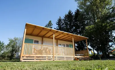 a small house with a porch on top of a field at Terme Village - Mobile Homes in Čatež ob Savi