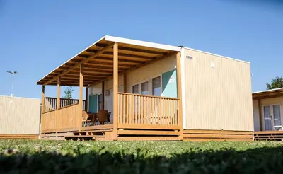 a house with a large porch with a deck at Terme Village - Mobile Homes in Čatež ob Savi