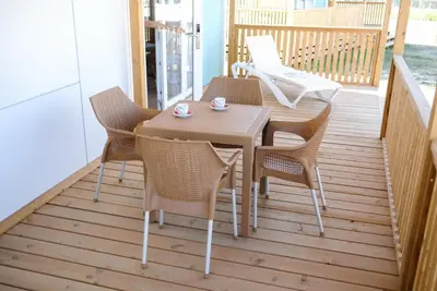 a wooden deck with a table and chairs on a porch at Terme Village - Mobile Homes in Čatež ob Savi