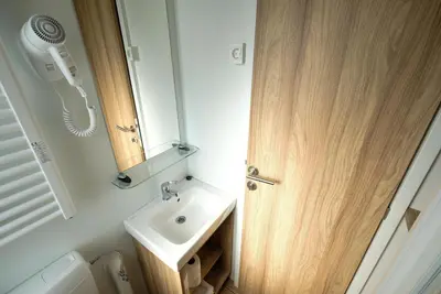 a small bathroom with a sink and a mirror at Terme Village - Mobile Homes in Čatež ob Savi