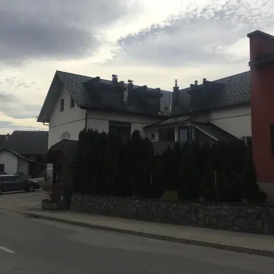 a white house with a fence in front of it at Gostilna in prenočišča Gedžo in Novo Mesto