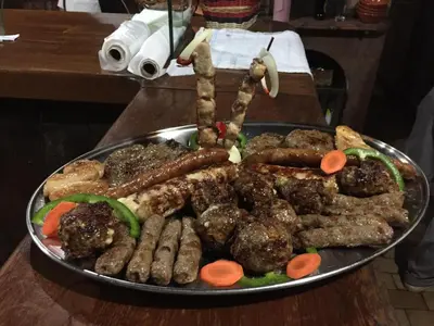 a plate of meat and sausage on a table at Gostilna in prenočišča Gedžo in Novo Mesto