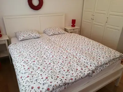 a bedroom with a bed with a floral comforter and pillows at Apartment Maša in Kranjska Gora
