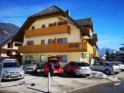a building with cars parked in a parking lot at Apartment Maša in Kranjska Gora
