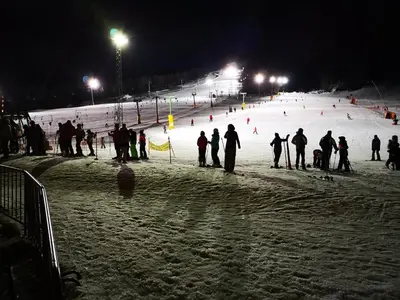a group of people on a ski slope at night at Apartment Maša in Kranjska Gora