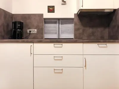 a kitchen with white cabinets and a counter top at Apartments Franc in Bled