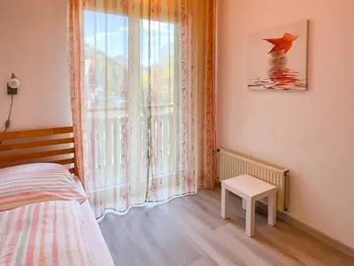 a bedroom with a bed and a window with an umbrella at Apartments Franc in Bled