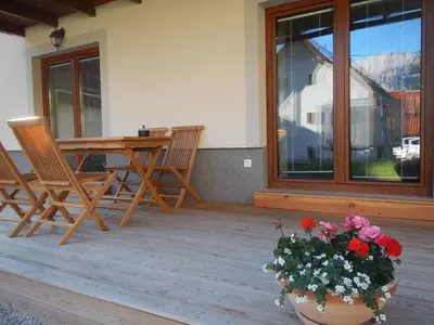 a patio with a table and chairs and flowers at Danijela & Gregor in Rateče