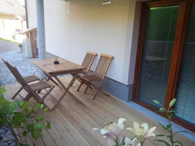 two chairs and a wooden table on a patio at Danijela & Gregor in Rateče