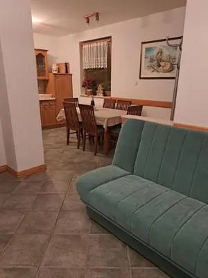 a living room with a green couch and a table at Apartma Smole in Kranjska Gora