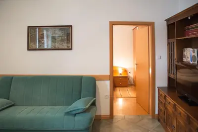 a living room with a green couch and a television at Apartma Smole in Kranjska Gora