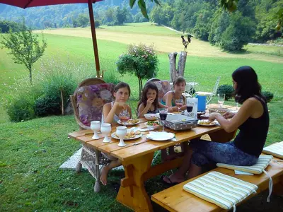 a group of children sitting at a picnic table at Apartments Green Paradise in Bohinjska Bela