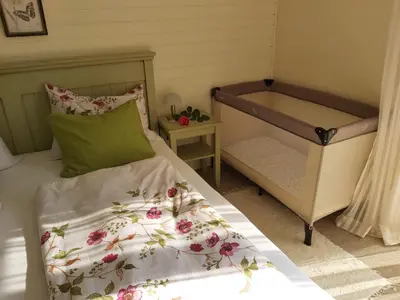 a small bedroom with a bed and a crib at Apartments Green Paradise in Bohinjska Bela