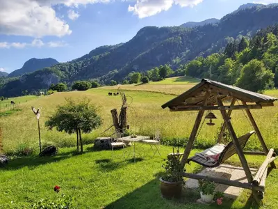 a garden with a bench and a table in a field at Apartments Green Paradise in Bohinjska Bela
