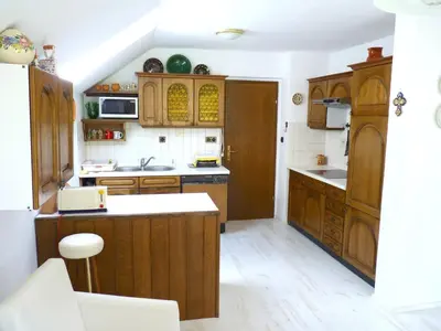 a kitchen with wooden cabinets and a counter top at Apartments Green Paradise in Bohinjska Bela