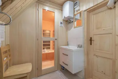 a small bathroom with a sink and a door at Chalet Encijan - Velika planina in Stahovica
