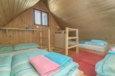 a room with two beds in a wooden cabin at Chalet Encijan - Velika planina in Stahovica