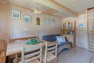 a dining room with a table and a blue couch at Chalet Encijan - Velika planina in Stahovica