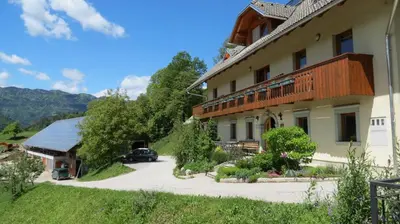 a building with a car parked in front of it at Tourist farm Mulej in Bled
