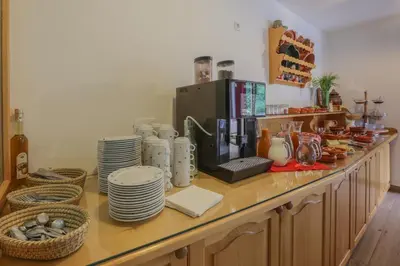 a counter with cups and plates and a coffee maker at Tourist farm Mulej in Bled