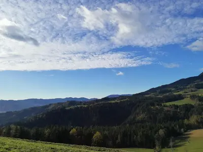 a view of a mountain range with a blue sky and clouds at Apartma Lesjak - pobeg v naravo 2 in Šmihel nad Mozirjem