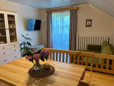 a living room with a table with flowers on it at Apartma Lesjak - pobeg v naravo 2 in Šmihel nad Mozirjem