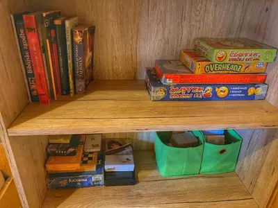 a wooden shelf with books and toys on it at Chalet Košutnik Velika planina in Kamniška Bistrica