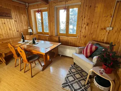 a living room with a wooden table and a couch at Chalet Košutnik Velika planina in Kamniška Bistrica