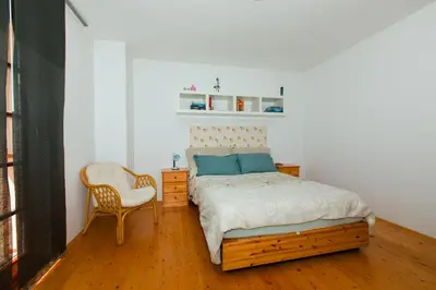 a bedroom with a bed and a chair at Thirsty River Apartments in Bovec