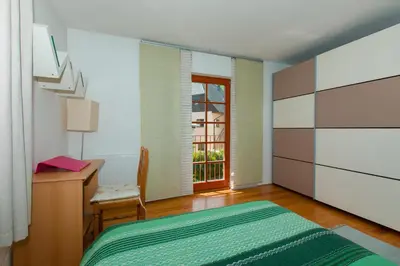 a bedroom with a bed and a desk and a window at Thirsty River Apartments in Bovec