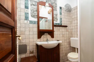 a bathroom with a sink and a toilet and a mirror at Apartments Valentinus 1800 in Sežana