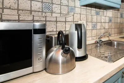 a kitchen counter with a tea kettle next to a microwave at Apartments Valentinus 1800 in Sežana