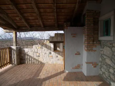 a porch of a house with a brick wall at Apartments Valentinus 1800 in Sežana