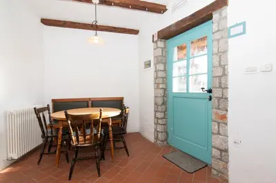 a room with a table and a blue door at Apartments Valentinus 1800 in Sežana
